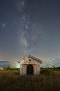 Small building under the milky way galaxy.